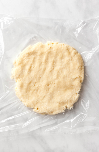Pie dough flattened out on a work surface.