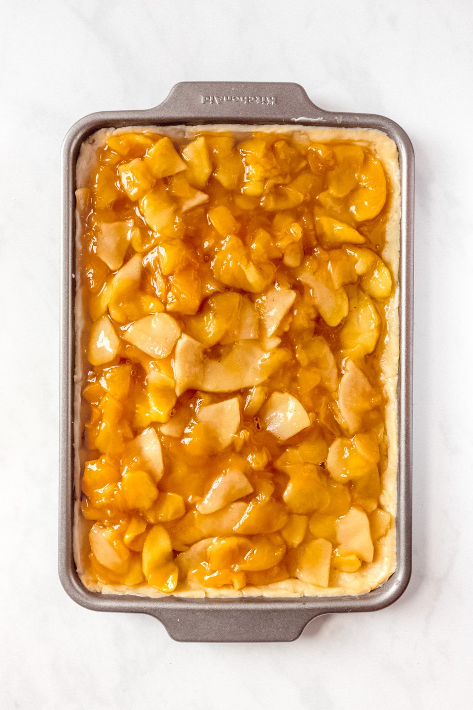 Sheet pan with bottom crust and pie filling on top.