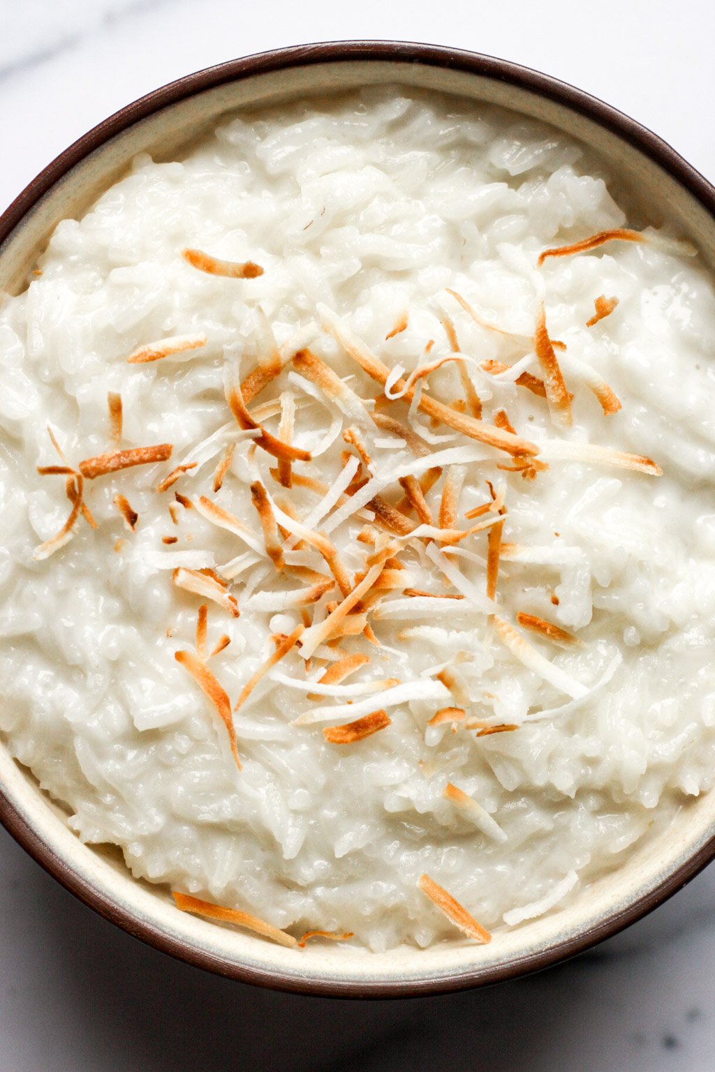creamy coconut rice pudding topped with toasted coconut flakes